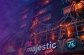 Fachada de Majestic Mall de noche, decorada con telaranas y luces de Halloween
